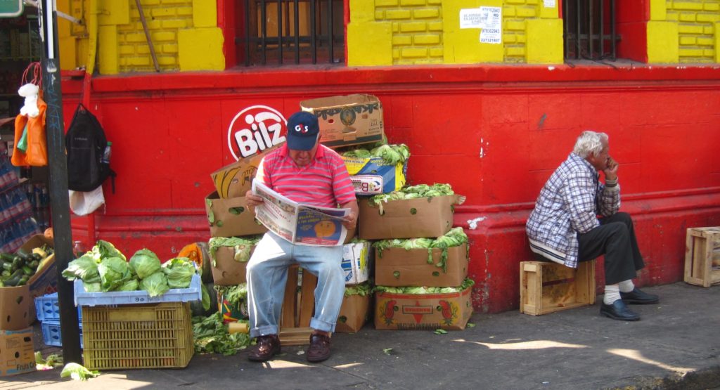 guy sitting on boxes of cabbage