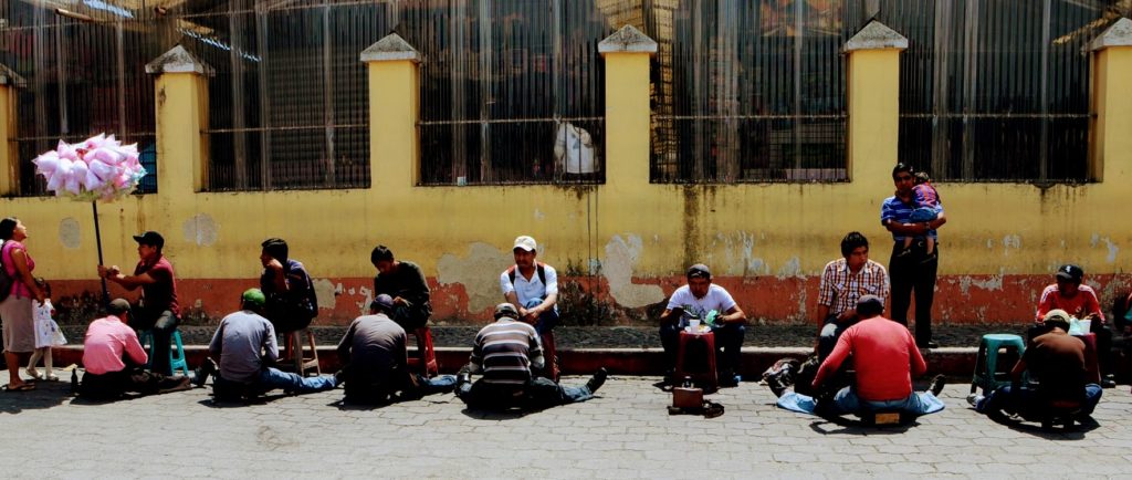 guys sitting on street and stools