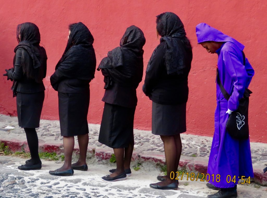 females lined up in black with a guy in purple behind them