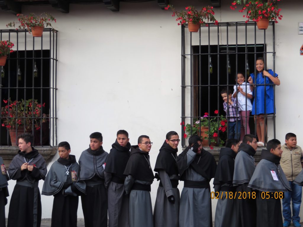 guy lined up in black with children in window
